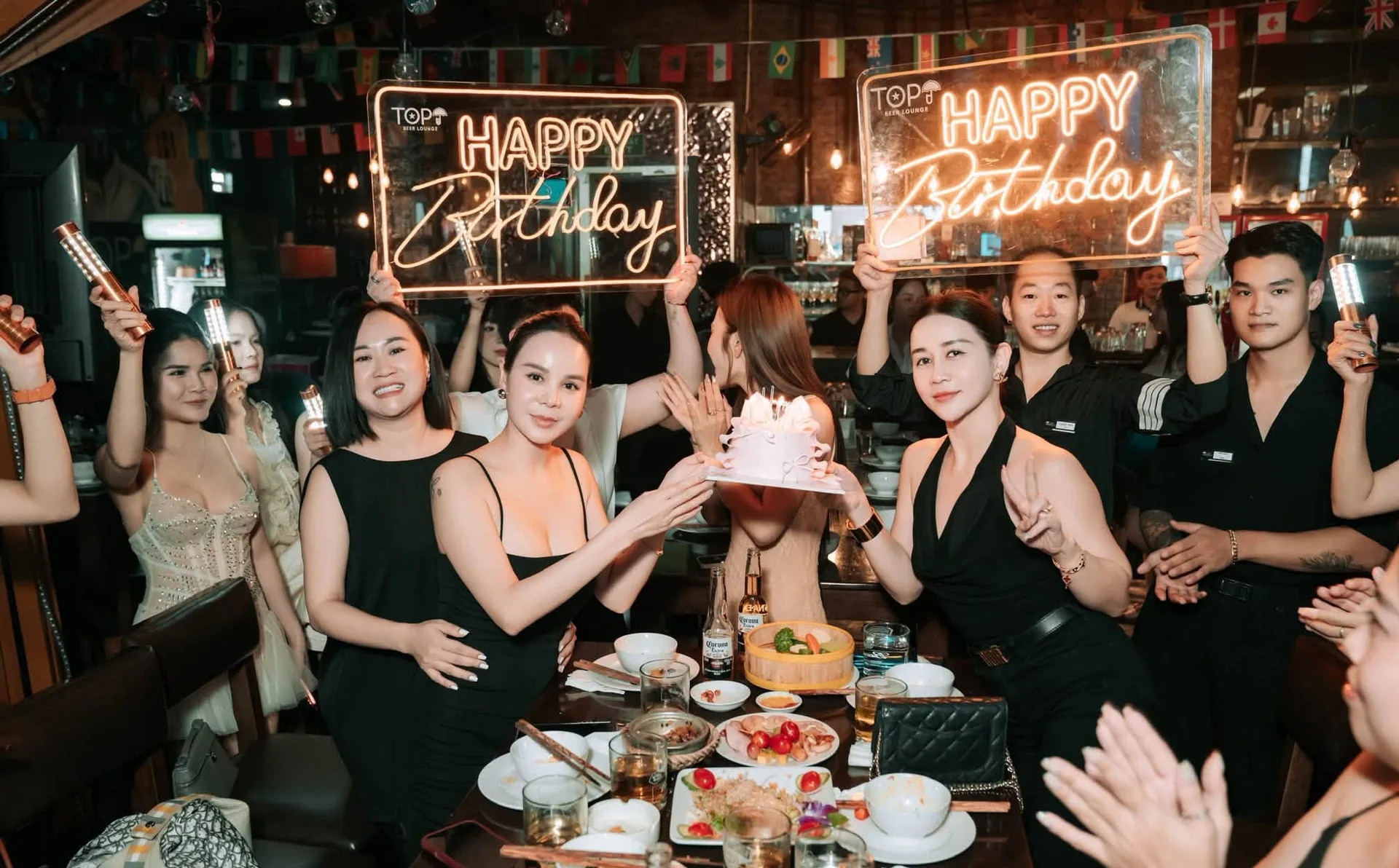 Hai bảng đèn Happy Birthday và bánh kem giữa bàn tiệc tại TOP.U